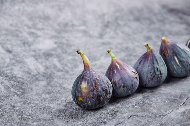 Ripe purple figs on a marble table.