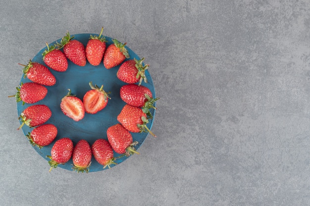 Ripe red strawberries on blue board. High quality photo