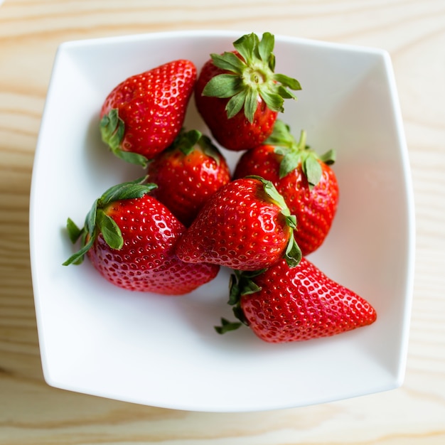 Ripe red strawberries on a plate.