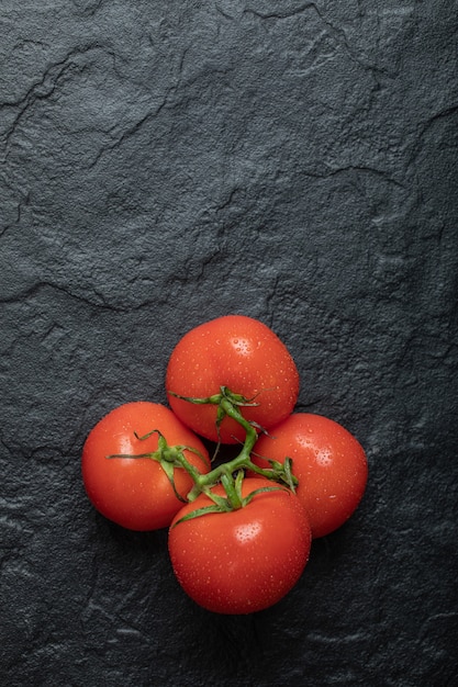 Бесплатное фото Спелые красные помидоры на темной поверхности