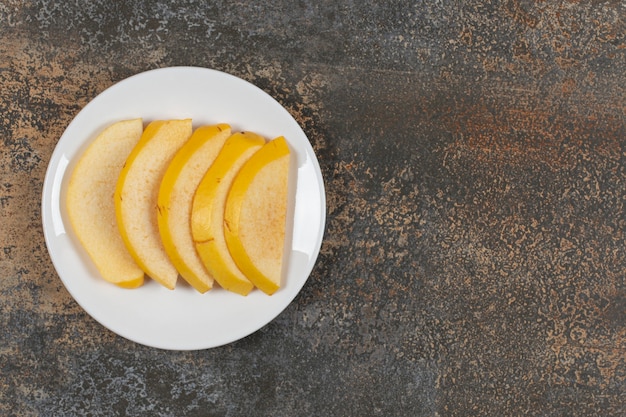 Ripe sliced quince on white plate