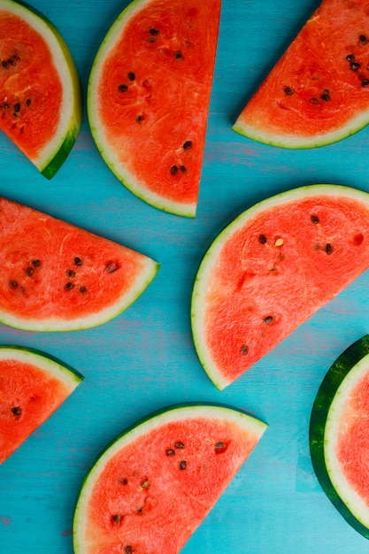Free photo ripe watermelon slices on a blue background. top view. vertical.