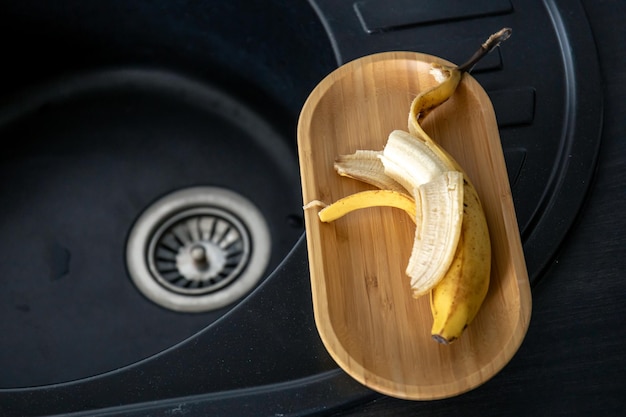 Foto gratuita banana gialla matura in cucina vicino al lavandino