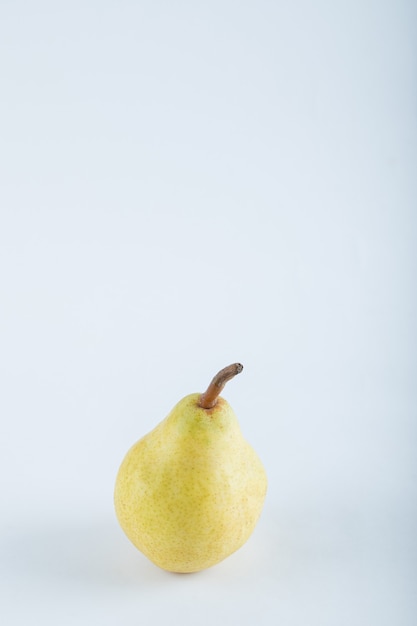 Спелая желтая груша на белом фоне. Фото высокого качества