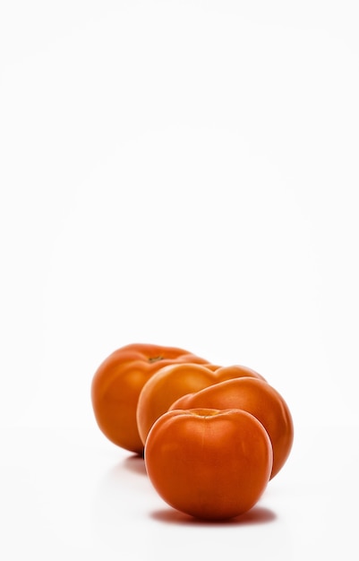 Ripe yellow tomatoes in a row on a white background, close-up, selective focus. Eco vegetables from the farm