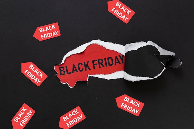 Ripped paper revealing black friday text with stickers