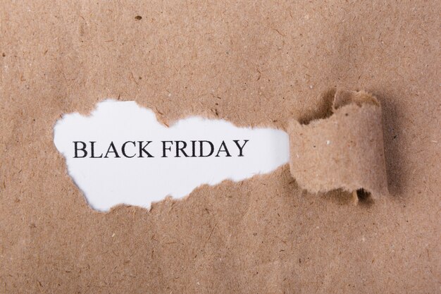 Ripped paper revealing black friday text