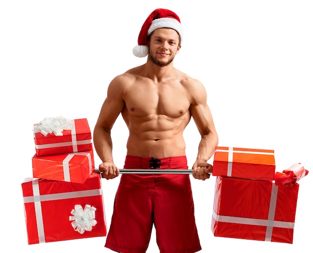 Free photo ripped santa holding a barbell with presents