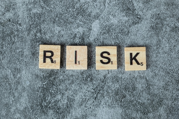 Free photo risk writing with black letters on wooden dices on the marble background