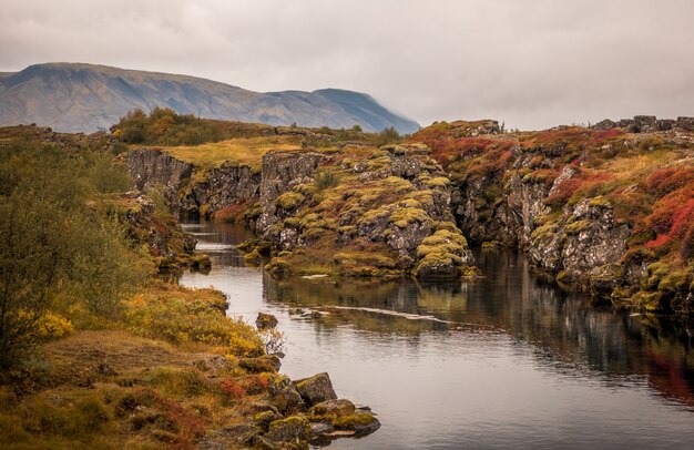 Река, текущая через скалы, запечатленная в национальном парке Тингвеллир в Исландии.