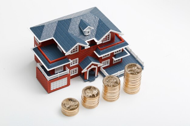 RMB coins stacked in front of the housing model (house prices, house buying, real estate, mortgage concept)