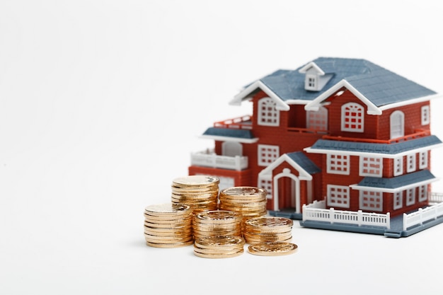 RMB coins stacked in front of the housing model (house prices, house buying, real estate, mortgage concept)