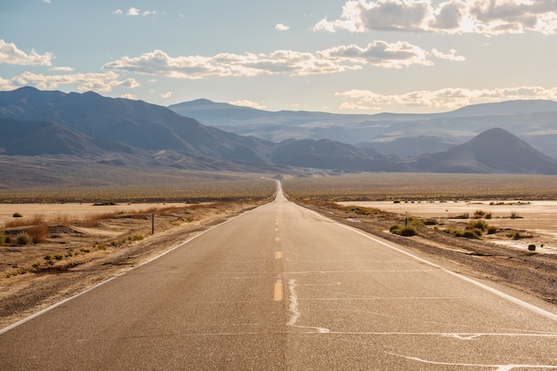 Дорога посреди пустыни с великолепными горами в Калифорнии