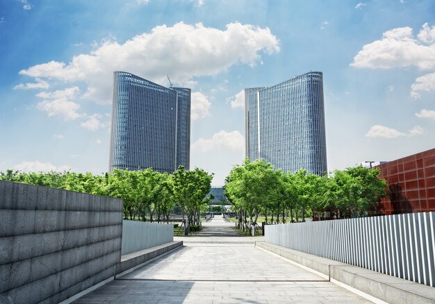 Road with trees into two symmetrical buildings