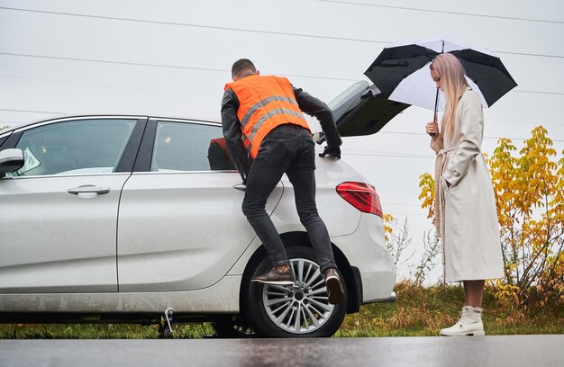 Free photo roadside assistance worker repairing woman car on the street