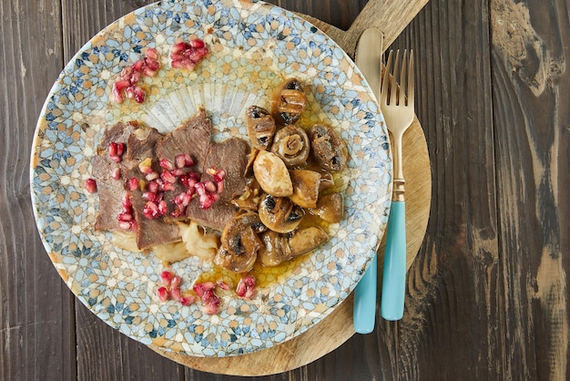 Roast beef with mushrooms and pomegranate seeds. french gourmet cuisine. flat lay