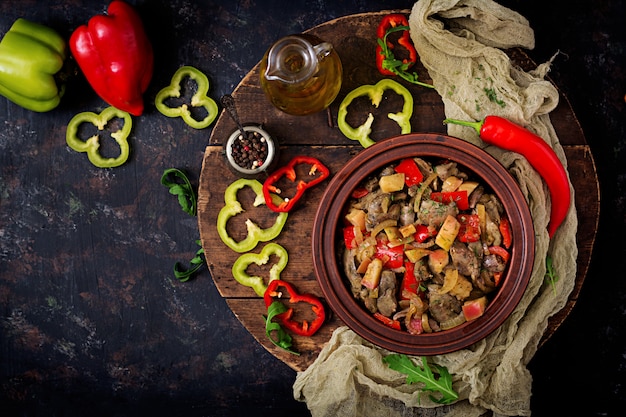 Roast chicken liver with vegetables on wooden background. Flat lay. Top view