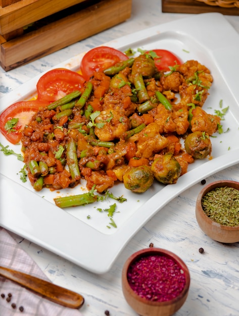 Roasted cauliflower with sprouts, beans and served with tomato sauce and herbs. 