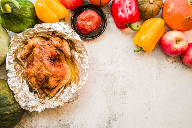 Roasted chicken in foil on table