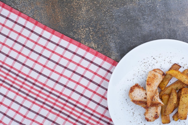 Roasted chicken and potatoes on white plate. High quality photo