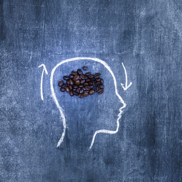 アウトラインの顔の中の焙煎されたコーヒー豆は黒板に矢印で表示されます