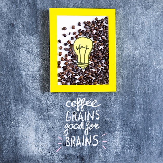 Roasted coffee beans and paper cutout light bulb frame with text on chalkboard