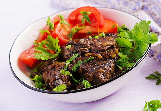 Roasted or grilled beef liver with onion and tomatoes salad