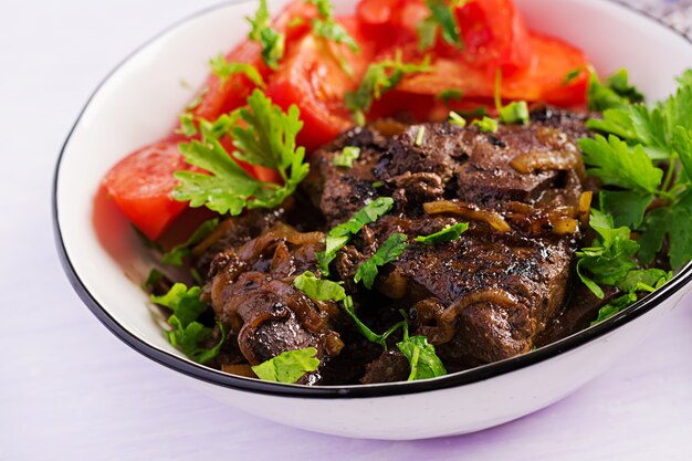 Roasted or grilled beef liver with onion and tomatoes salad