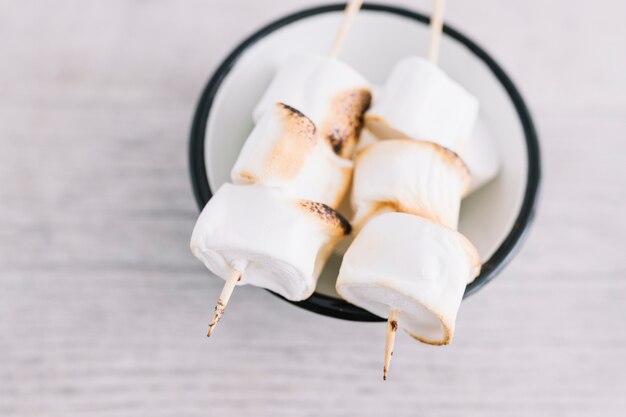 Roasted marshmallows on wooden sticks