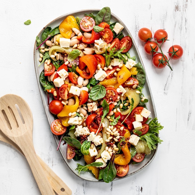 Free photo roasted pepper and butter bean salad with harissa dressing on white background