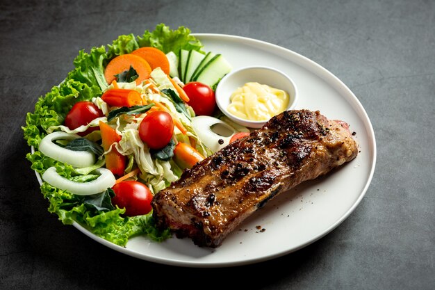 Roasted pork steak and vegetables on plate.