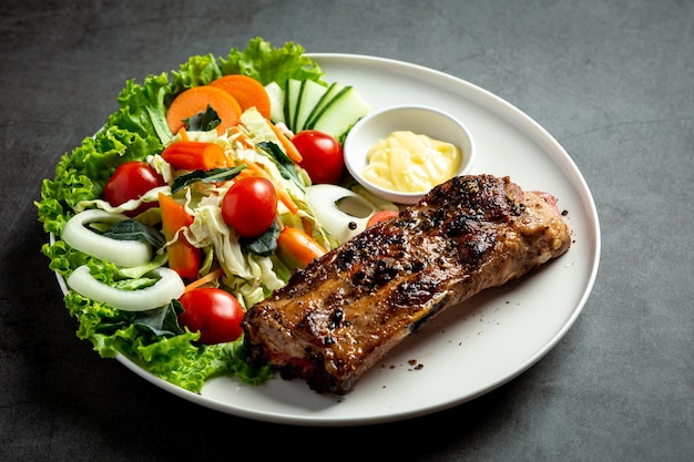Roasted pork steak and vegetables on plate.