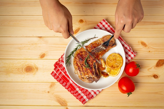 Roasted pork steak on wooden surface.