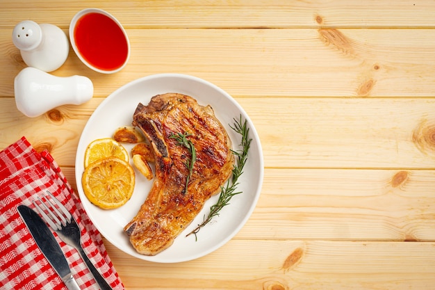 Roasted pork steak on wooden surface.