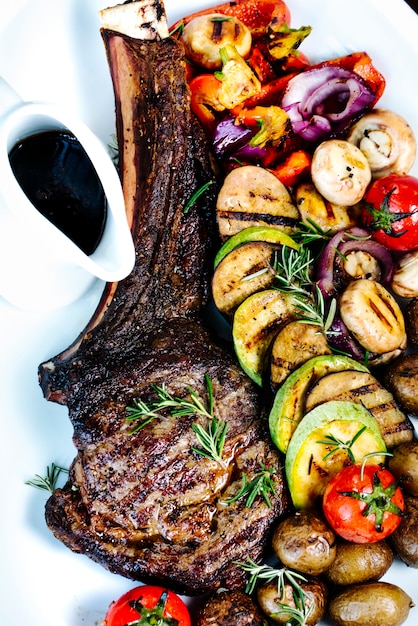 Free photo roasted rib with sliced fried vegetables and sauce