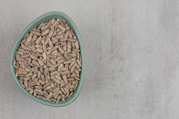 Roasted sunflower seeds in blue bowl.