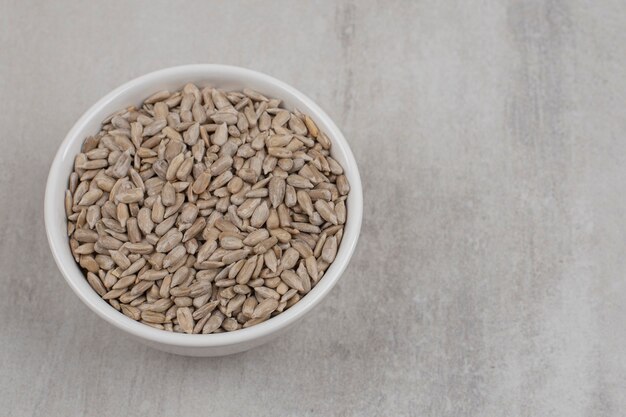 Roasted sunflower seeds in white bowl.