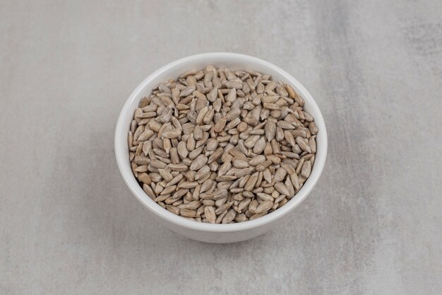 Roasted sunflower seeds in white bowl.