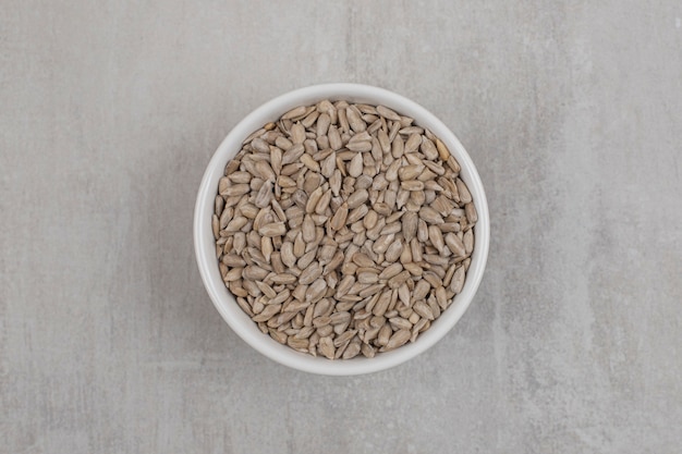 Roasted sunflower seeds in white bowl.