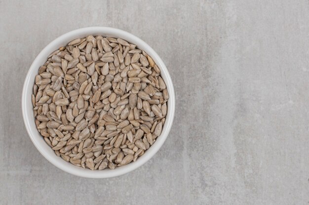 Roasted sunflower seeds in white bowl.