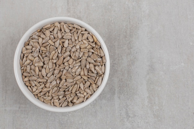 Roasted sunflower seeds in white bowl.