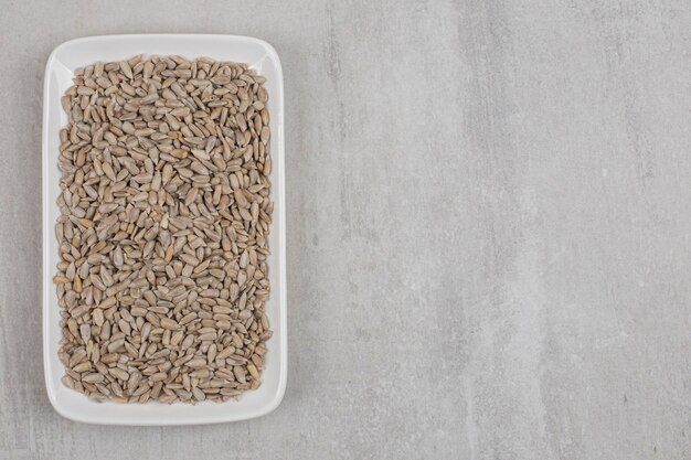 Roasted sunflower seeds on white plate.