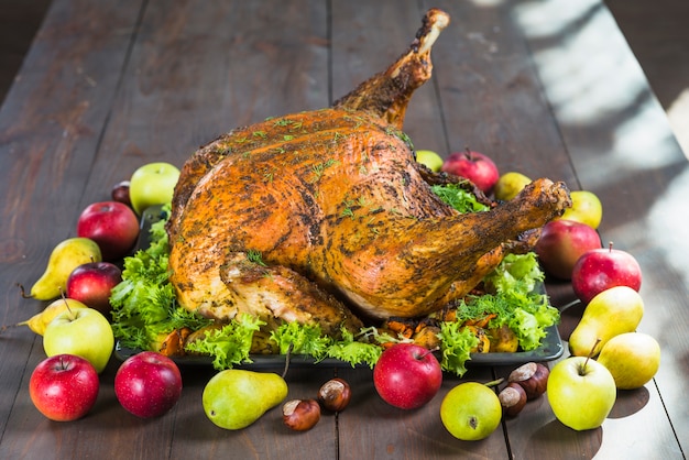 Roasted turkey with fruits on table