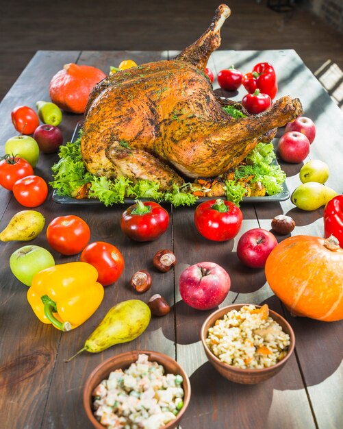 Roasted turkey with vegetables on wooden table