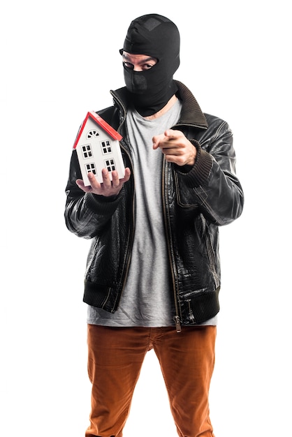 Free photo robber holding a little house