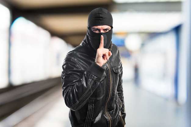 Robber making silence gesture