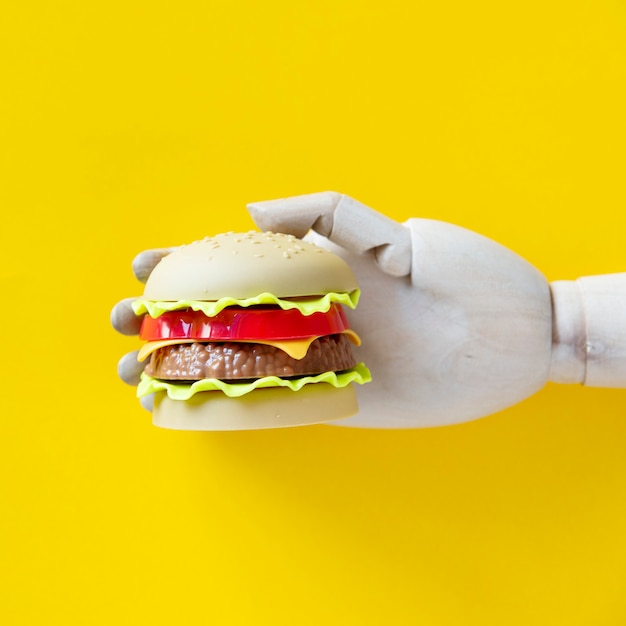 Free photo robot hand holing a hamburger