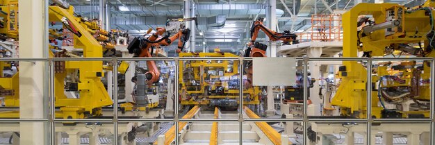 Robotic equipment collects cars on the production line Long format shooting automotive Car factory banner