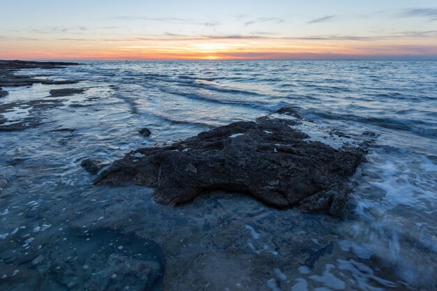 日没時にクロアチア、イストリア半島、サヴドリアのアドリア海の海岸の奇岩