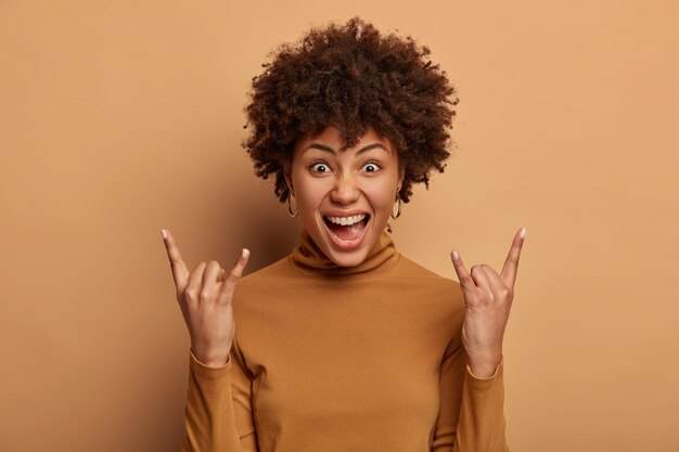 Rock n roll lives forever emotional dark skinned woman makes heavy metal sign